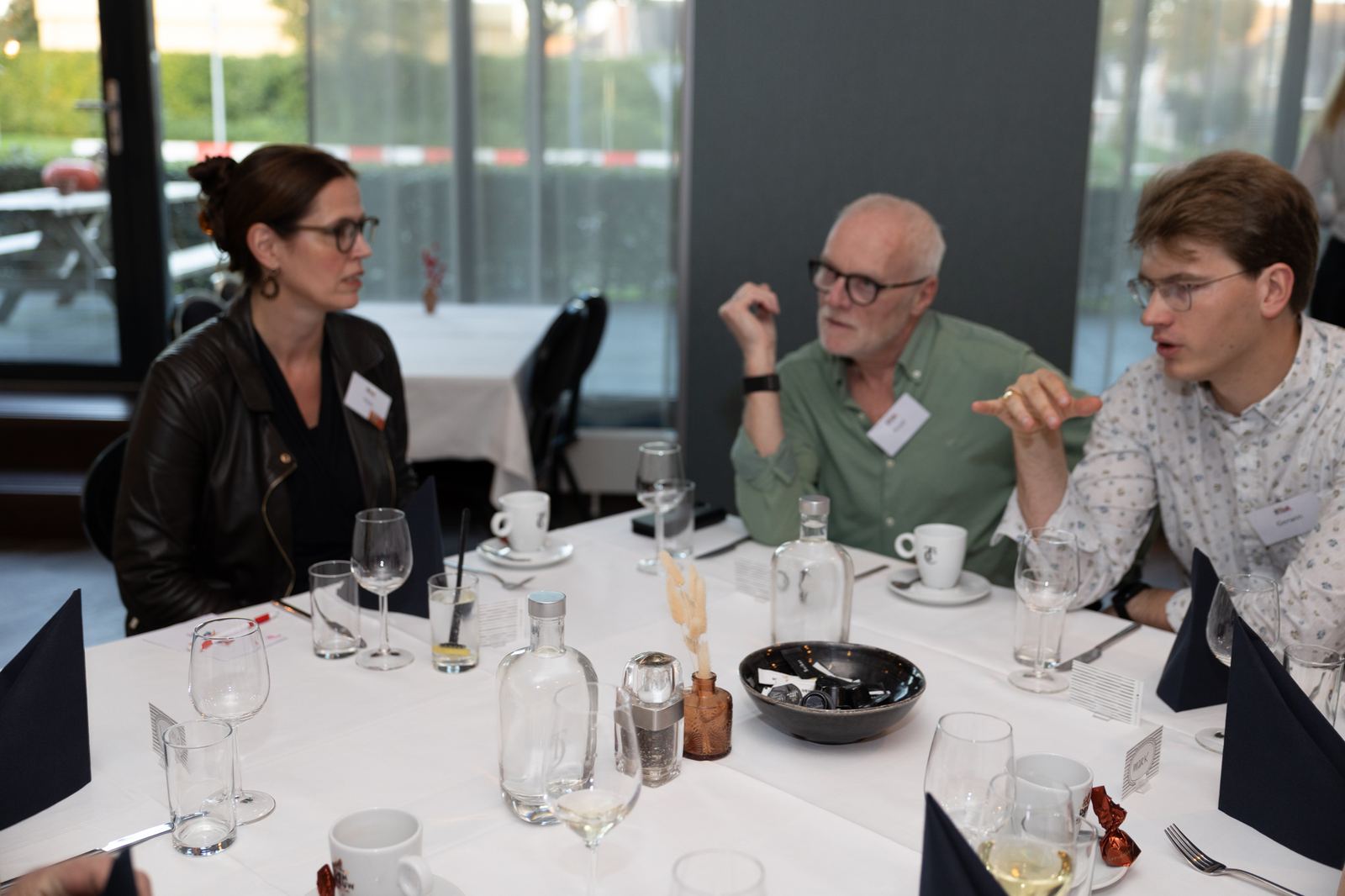 Deelnemers en een coach in gesprek aan de dinertafel